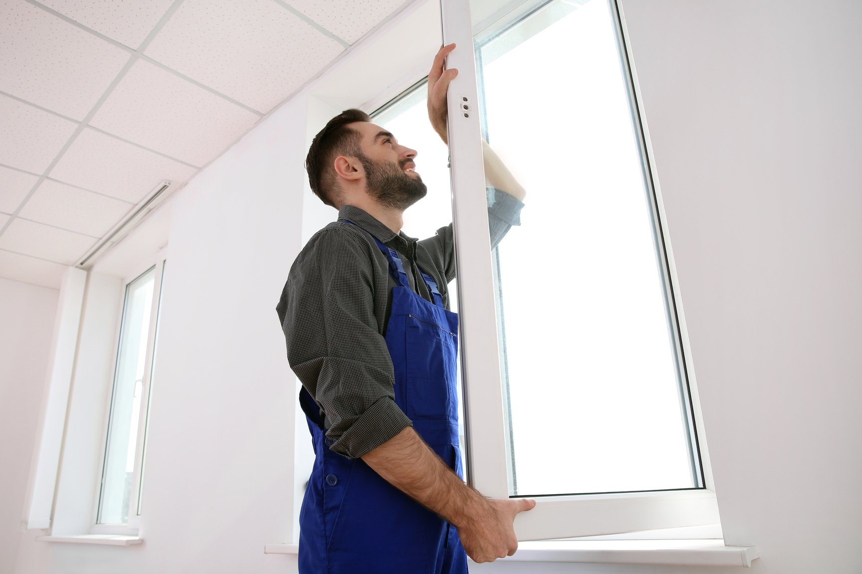 Construction Worker Installing Plastic Window in House